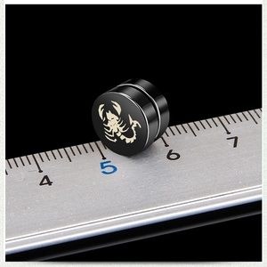 Black magnetic scorpion earring in stainless steel shown with a scale ruler for size