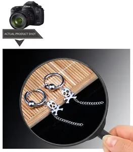 Macro detail of silver stainless steel hoop earring with skull charm and long chain fringe