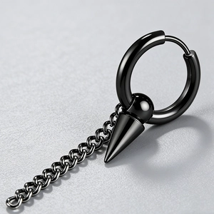 Détail macro d'une boucle d'oreille punk noire avec chaîne, boule et pendentif à pointe