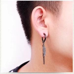 Détail d'une boucle d'oreille noire avec pendentif plume et chaîne pour hommes