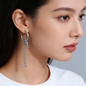 Boucle d'oreille punk en acier titane argenté avec chaîne et pic conique sur un modèle