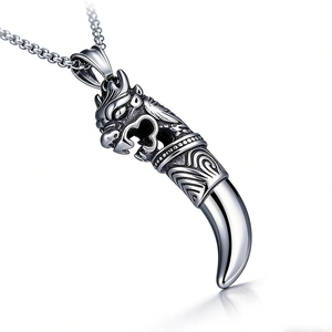Détail du pendentif tête de dragon et dent de loup en acier inoxydable vintage