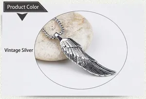 Detail of antique silver wing pendant with intricate feather texture and steel chain