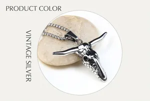 Macro shot of antique silver ox skull pendant on a smooth stone with a vintage round link chain