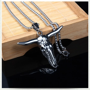Macro shot of polished silver bull skull pendant with stainless steel box chain