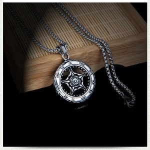 Détail du pendentif gouvernail ancre vintage argenté avec gravure sur chaîne en acier