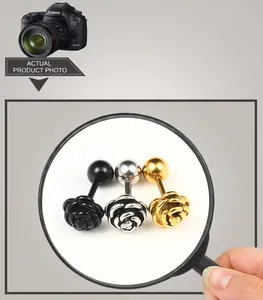 Detailed macro view of rose flower stud earrings in black, silver, and gold titanium steel