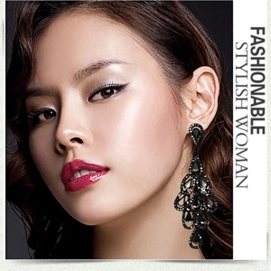 Detail view of black layered hollow waterdrop earrings with crystals on an Asian model