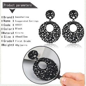 Macro detail of black hollow mesh earrings featuring encrusted crystals and zinc alloy texture