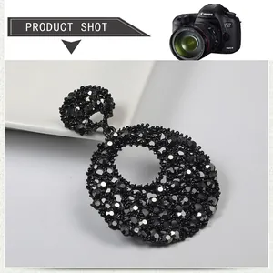 Close-up of luxury black rhinestone earrings with intricate hollow retro round patterns
