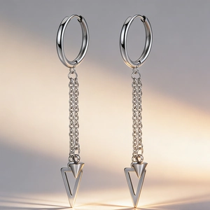 Détail de boucles d'oreilles en acier argenté avec doubles chaînes et pendentif triangle