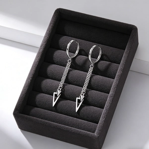 Gros plan de boucles d'oreilles créoles en acier argenté avec double chaîne et charms