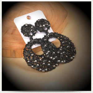 Detailed view of large black faceted bead hollow hoop earrings on a display card
