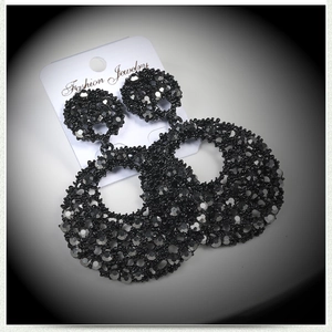 Detailed macro shot of vintage black rhinestone hoop earrings on a display card