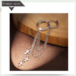 Detail of silver stainless steel hoop earrings with triple chains and cross pendants