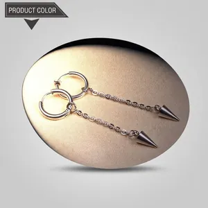 Close-up of silver steel hoop earrings with hanging chain and cone pendant detail