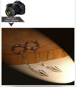 Detailed close-up of stainless steel hoop earrings with long chain and spike pendants