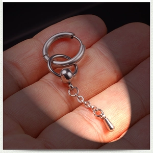 Macro shot of polished stainless steel dangle earring with chain and oval pendant