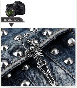 Detailed view of punk style silver stainless steel skull stud earring on denim background