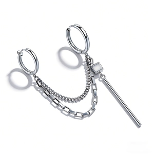 Close-up of double hoop steel earrings with industrial chains and cylindrical pendant