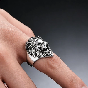 Detailed close-up of a silver lion head ring with punk style texture on finger