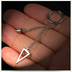 Détail d'une boucle d'oreille en acier argenté avec chaîne punk et pendentifs géométriques