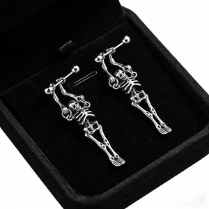 Macro shot of vintage silver skull bone stud earrings in a black jewelry box
