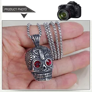Detailed punk skull pendant in vintage steel with red gemstone eyes and floral carvings