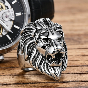 Close-up of retro lion totem stainless steel ring on a textured wood surface