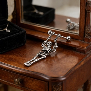 Macro detail of vintage skull skeleton earring in antique silver on wooden background