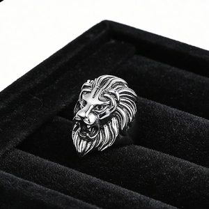 Macro view of retro stainless steel lion head totem ring with detailed engraving on black velvet