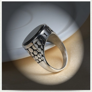 Vintage stainless steel ring for men featuring an oval black gemstone and embossed details