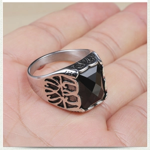 Gros plan de la bague chevalière pour homme en acier avec pierre noire et détails gravés