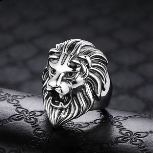 Detailed macro shot of silver lion head ring with intricate engraving on leather