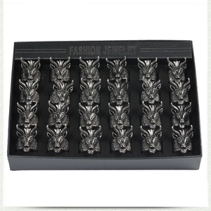 Macro shot of 24 vintage ram head totem rings organized in a black jewelry display box
