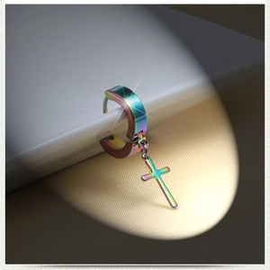 Macro view of rainbow plated stainless steel huggie hoop with a hanging cross pendant