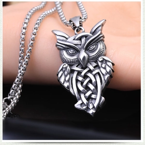 Close-up of vintage eagle owl pendant with intricate Celtic knots on stainless steel