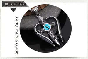 Macro detail of retro silver angel wing pendant with cross and blue turquoise stone inlay