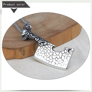Macro detail of gothic axe pendant with skull engraving and cracked vintage silver finish