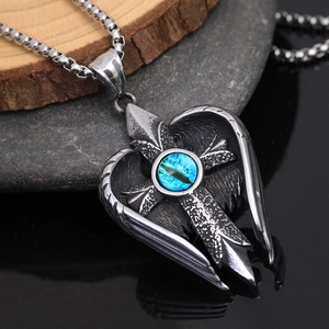 Macro detail of gothic angel wing pendant with blue turquoise and cross on steel chain