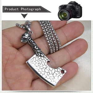 Detailed macro shot of vintage stainless steel axe pendant with skull engraving detail