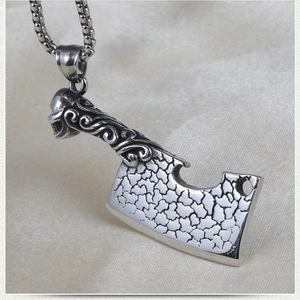 Macro view of skull handle and textured cleaver pendant on stainless steel chain