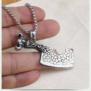 Détail du collier punk hip hop avec un pendentif en forme de couperet à tête de mort