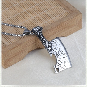 Macro detail of vintage style cleaver pendant with engraved patterns and box chain