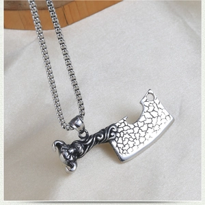 Détail du collier punk hip-hop en forme de couperet avec poignée démon et texture acier