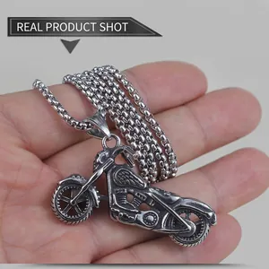 Macro detail of vintage silver motorcycle pendant with chunky stainless steel ball chain