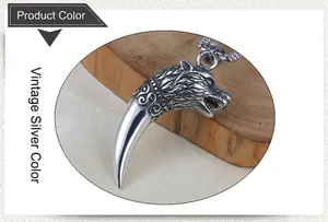 Macro shot of antique silver wolf head pendant with intricate tribal engraving on wood
