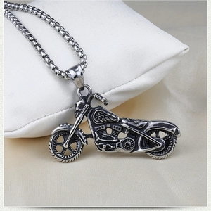 Detailed close-up of a vintage steel motorcycle pendant on a silver box chain