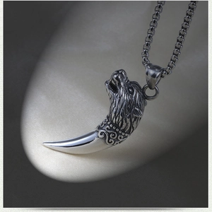 Close-up of vintage wolf head pendant in polished stainless steel for men