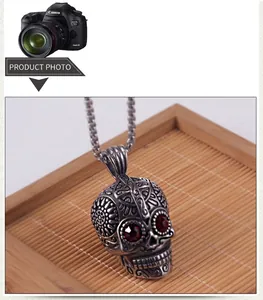 Macro detail of gothic skull pendant with red gem eyes and vintage floral engravings